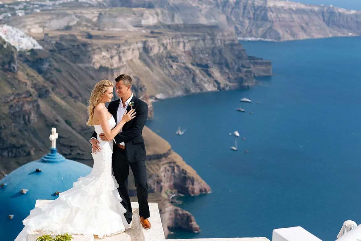 Symbolic wedding ceremony on a Santorini cliff at sunset