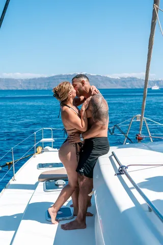 Santorini catamaran couple kiss