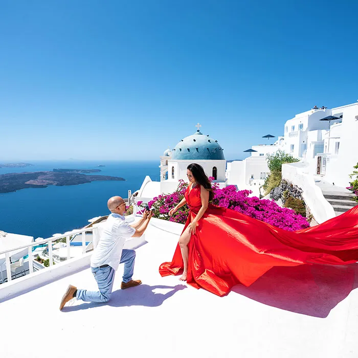 red flying dress photoshoot on a terrace in Oia